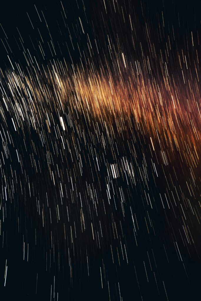 Long exposure of light streaks illuminating the night sky, creating a stunning celestial effect.